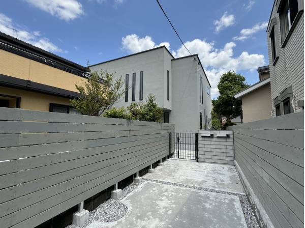 長い土間打ちが施された専用通路。その奥に品格を感じる建物が見えます。